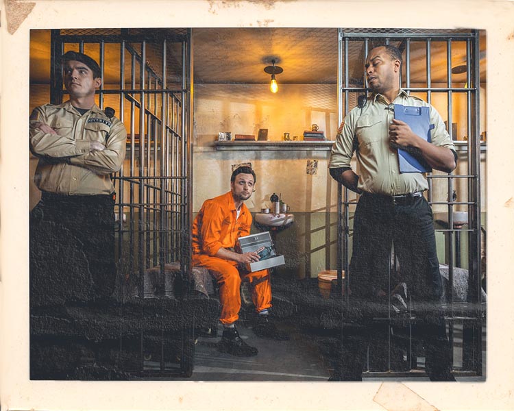 Inmate in cell at Alcotraz Liverpool - authentic prison-themed immersive cocktail bar experience.