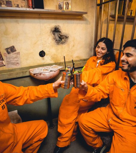 Friends in jumpsuits enjoying birthday celebration at Alcotraz - prison-themed immersive cocktail bar for fun nights out.