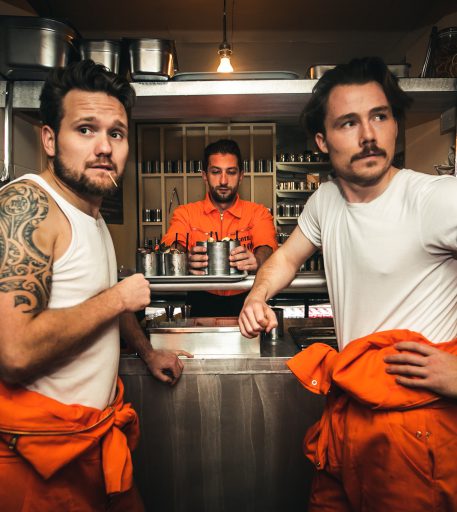Inmates in Brighton Alcotraz prison cell - authentic setting in this immersive cocktail bar experience.