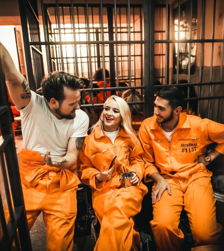 Couple enjoying cocktails at Alcotraz Brighton location - prison-themed cocktail bar experience.