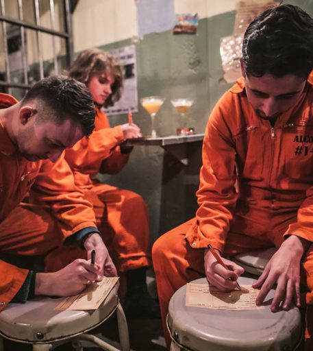 Friends in Alcotraz Shoreditch prison cell - original London location of this immersive cocktail bar experience.
