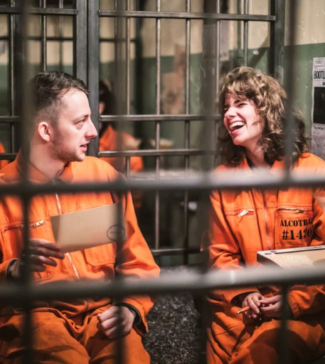 Couple enjoying cocktails during date night at Alcotraz - immersive and interactive prison-themed cocktail bar experience.