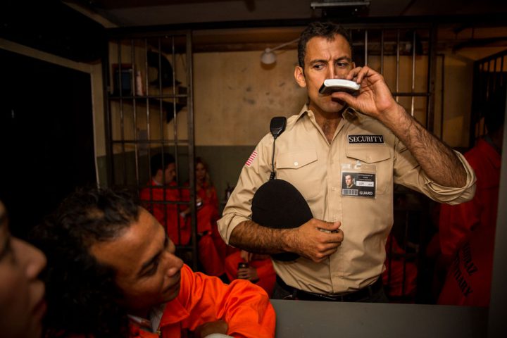 Prison security character interacting with customers at Alcotraz Shoreditch London venue - immersive bar experience.