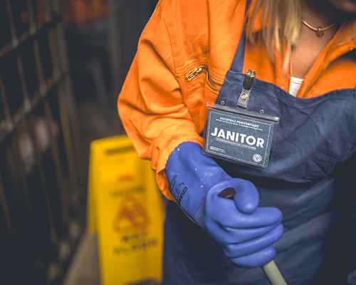 Prison janitor character at Alcotraz - staff member enhancing the immersive cocktail bar experience.
