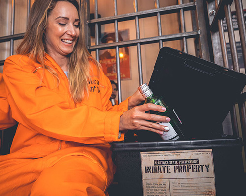 Inmate smuggling contraband alcohol into Alcotraz - key part of the immersive prison bar experience storyline for interactive fun