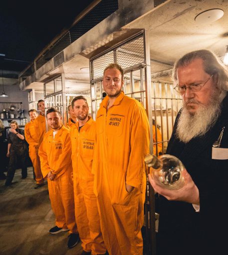 Prison warden patrolling cells at Alcotraz - character interaction in this immersive cocktail bar experience.