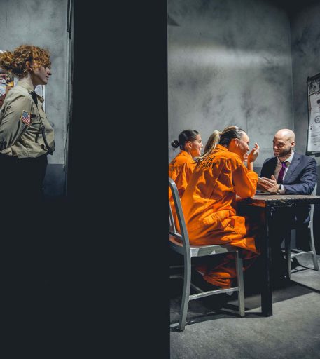 Prison guard interacting with visitors at Alcotraz in cell - theatrical elements of this immersive cocktail bar.