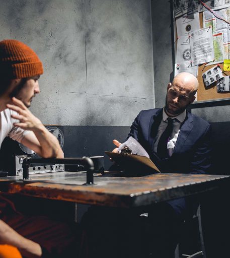 Prison warden character interrogating inmate at Alcotraz - key performer in this immersive cocktail bar experience.
