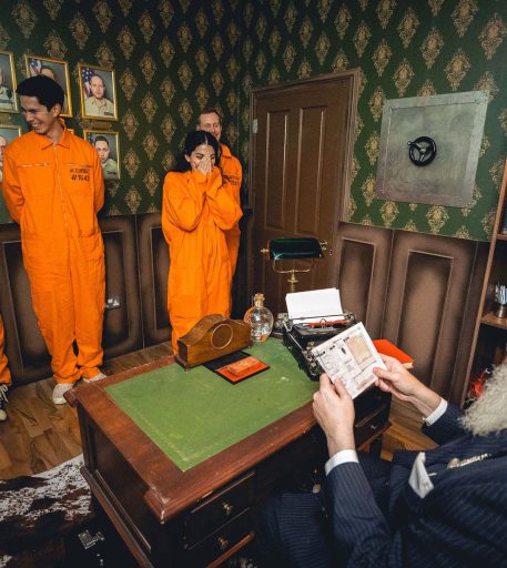Prison guard interacting with customers in orange jumpsuits at Alcotraz - interactive prison cocktail bar.