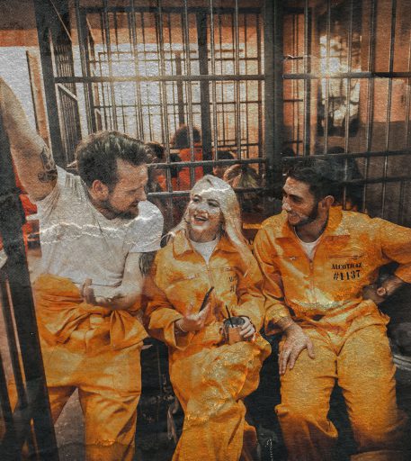 Friends in orange jumpsuits at Alcotraz - prison-themed immersive cocktail bar.
