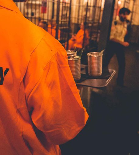 Inmates receiving contraband cocktails at Alcotraz - key part of the immersive prison bar storyline.