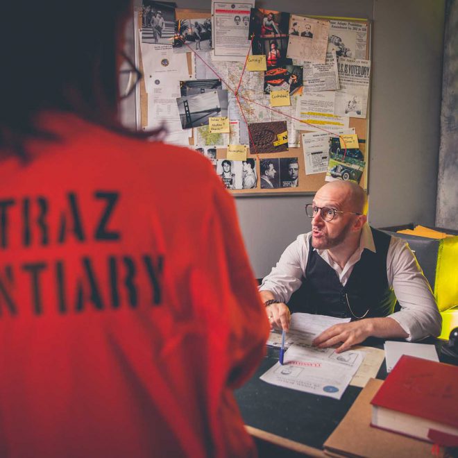 Prison guard character interacting with customers at Alcotraz - immersive cocktail bar experience.