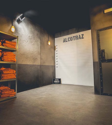 Prison interior with orange jumpsuits and mug shot background - immersive prison themed cocktail bar experience.