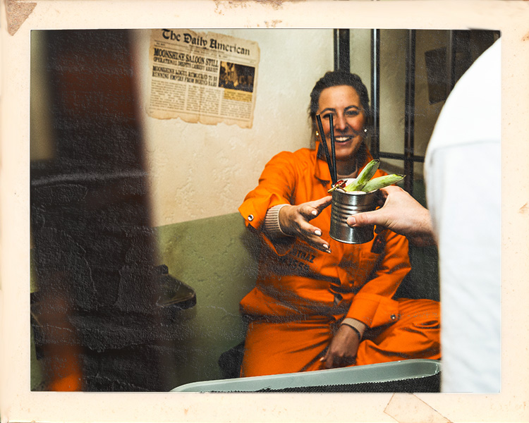 Inmate enjoying cocktails during birthday celebration at Alcotraz - immersive prison bar experience.