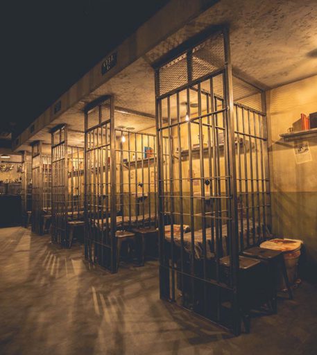 Prison cell interior design at Alcotraz - interactive jail cocktail bar for fun activities.