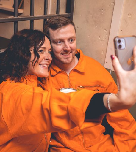 Couple taking selfie during date night at Alcotraz - memorable immersive prison bar experience for romantic evenings.