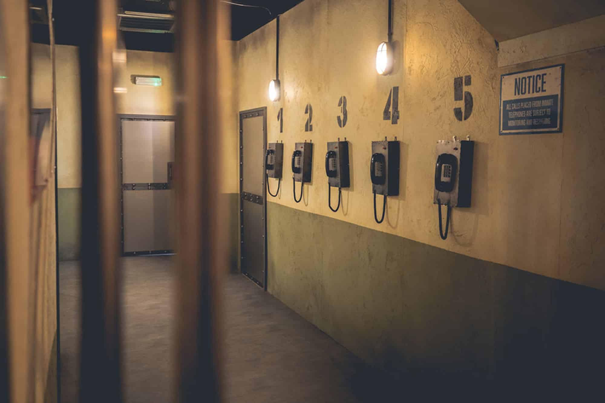 Prison cell interior detail at Alcotraz - authentic phone props enhancing this immersive cocktail bar experience