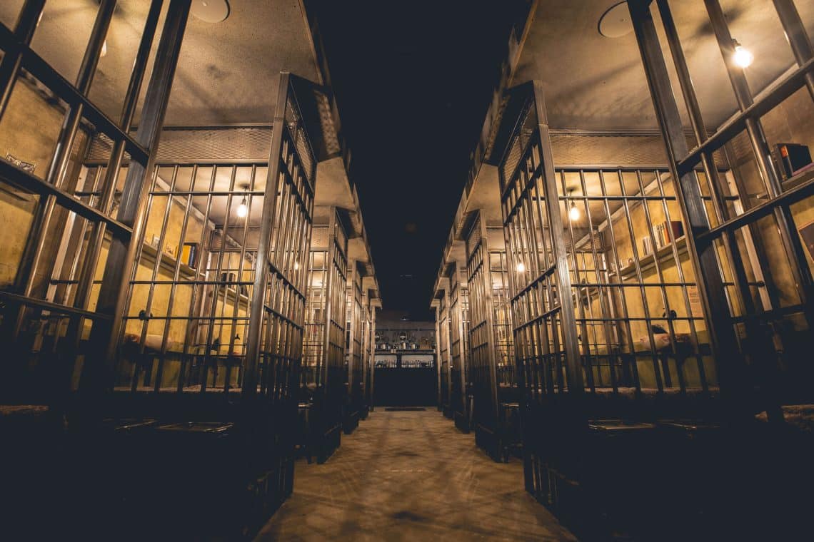 Wide view of prison cell block at Alcotraz - immersive cocktail bar setting for unique activity nights.