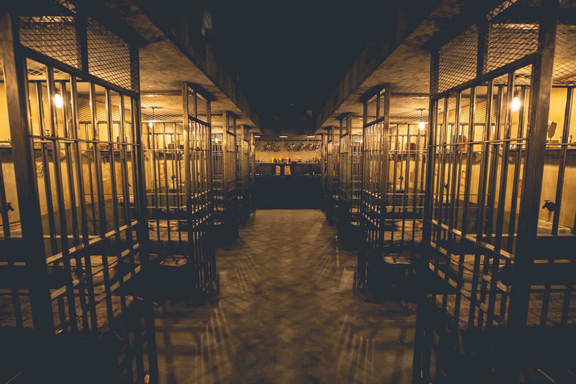 Wide view of prison cell block at Alcotraz - immersive cocktail bar setting for unique activity nights.