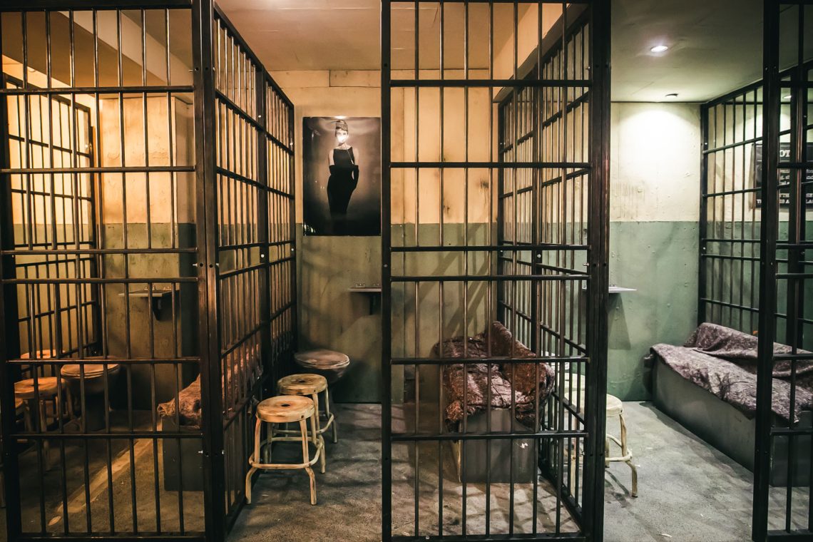 Wide view of prison-themed bar at Alcotraz - immersive cocktail experience setting for unique nights out.