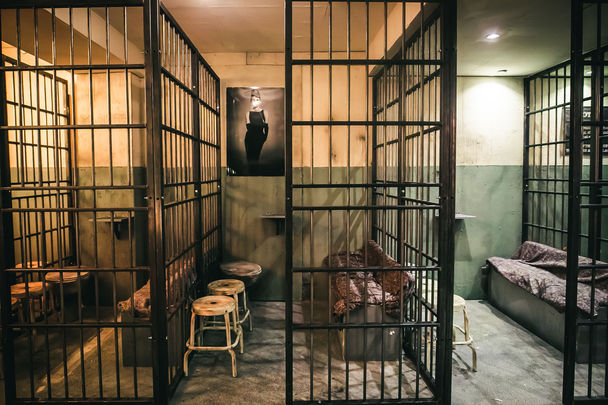 Wide view of prison-themed bar at Alcotraz - immersive cocktail experience setting for unique nights out.