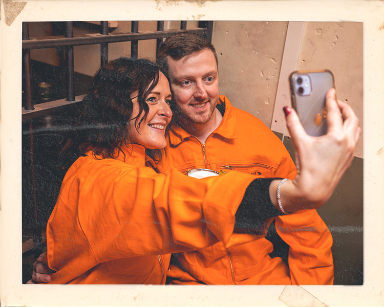 Couple taking selfie during date night at Alcotraz - memorable immersive prison bar experience for romantic evenings.